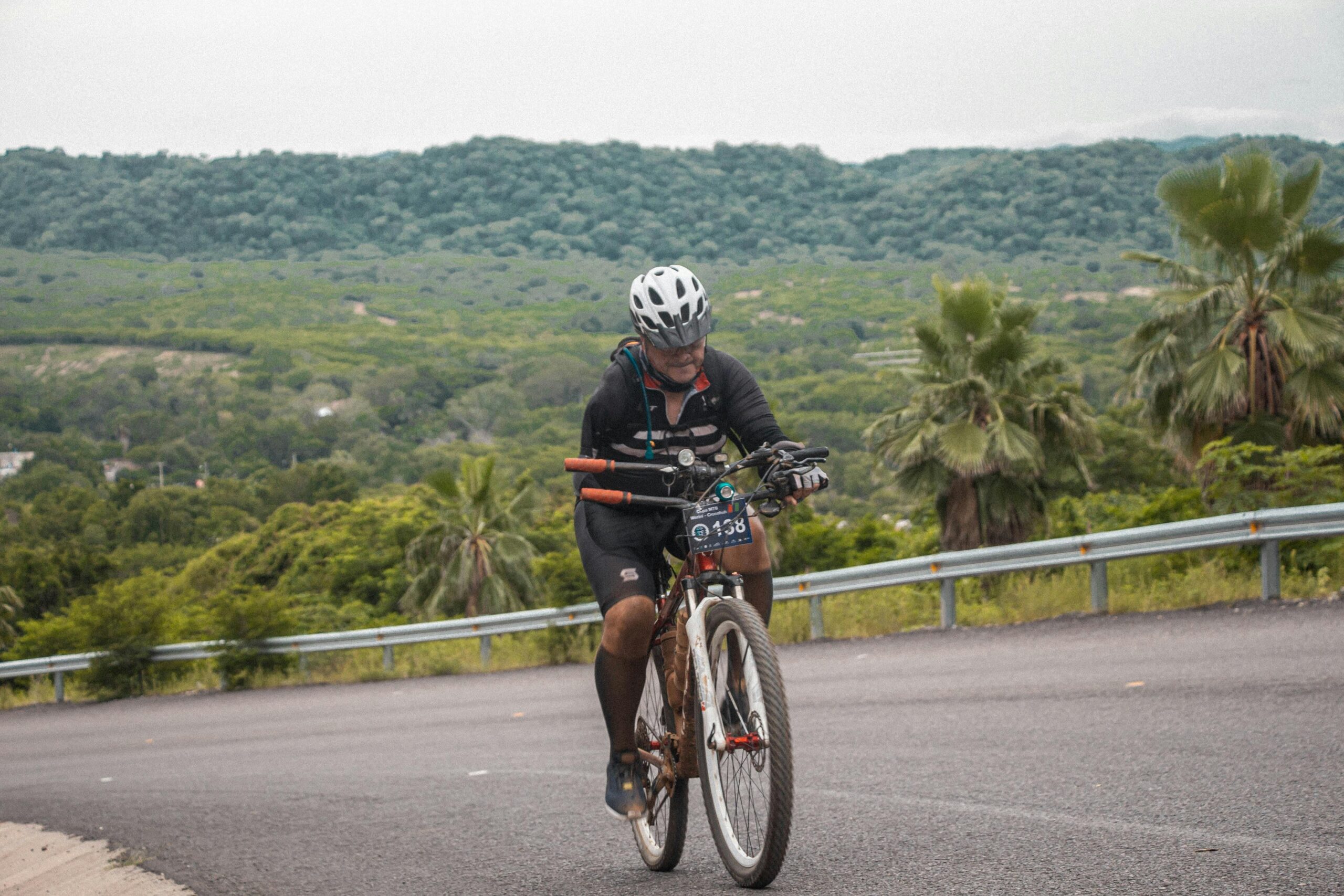 A cyclist riding an ebike uphill on a scenic trail
