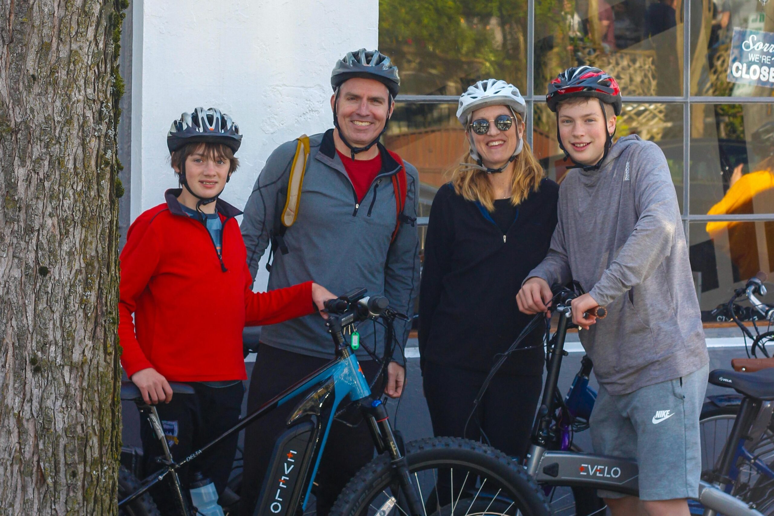 A group of cyclists pausing at the top of a mountain, smiling triumphantly