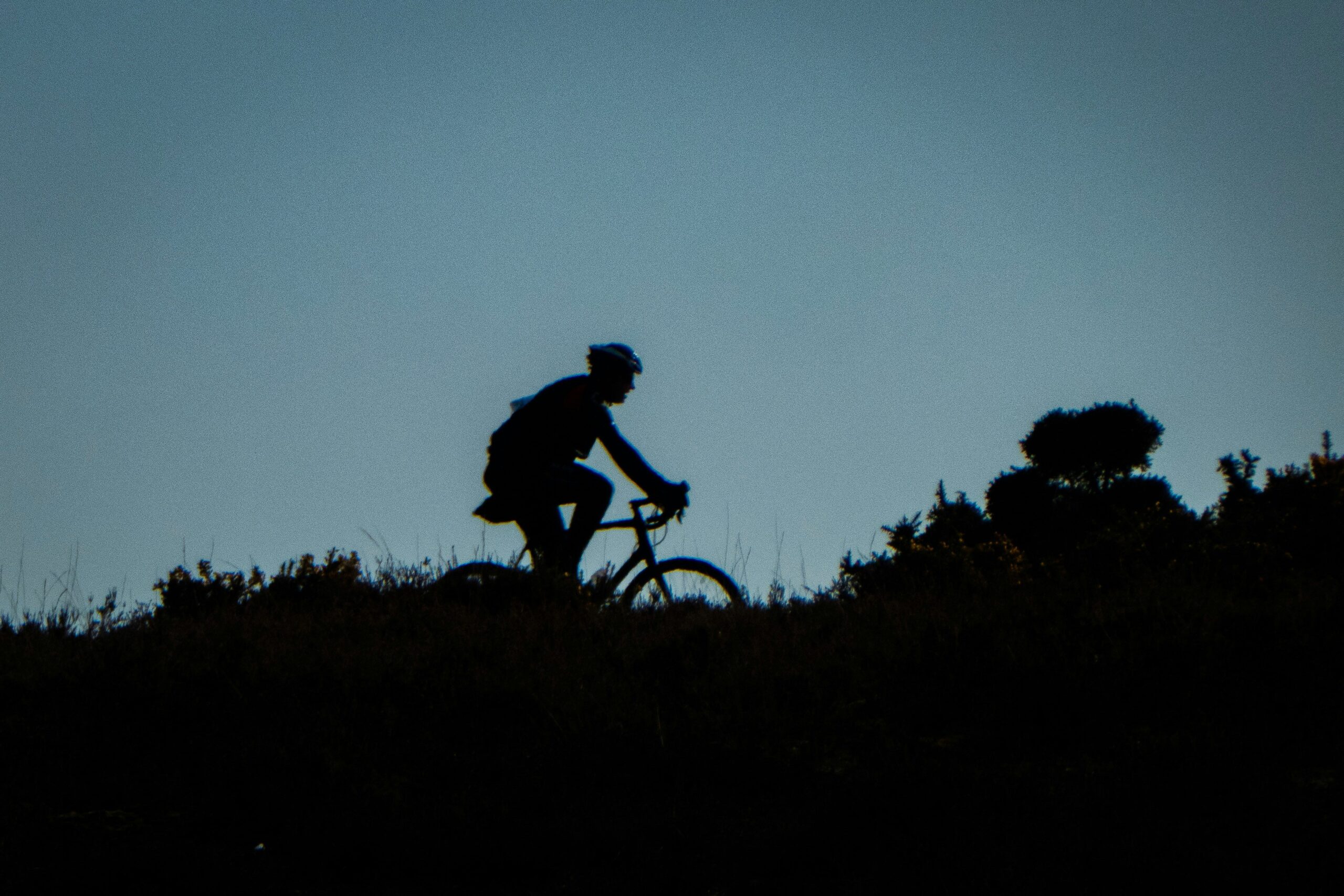 A cyclist riding uphill on an electric bike.
