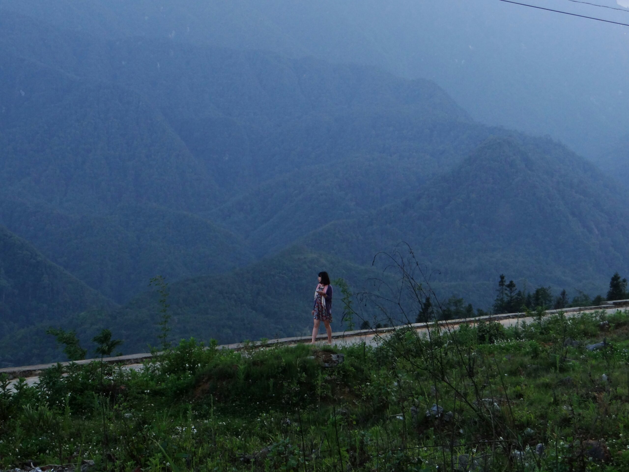 Sarah posing proudly atop her ebike overlooking mountains during her guided tour.