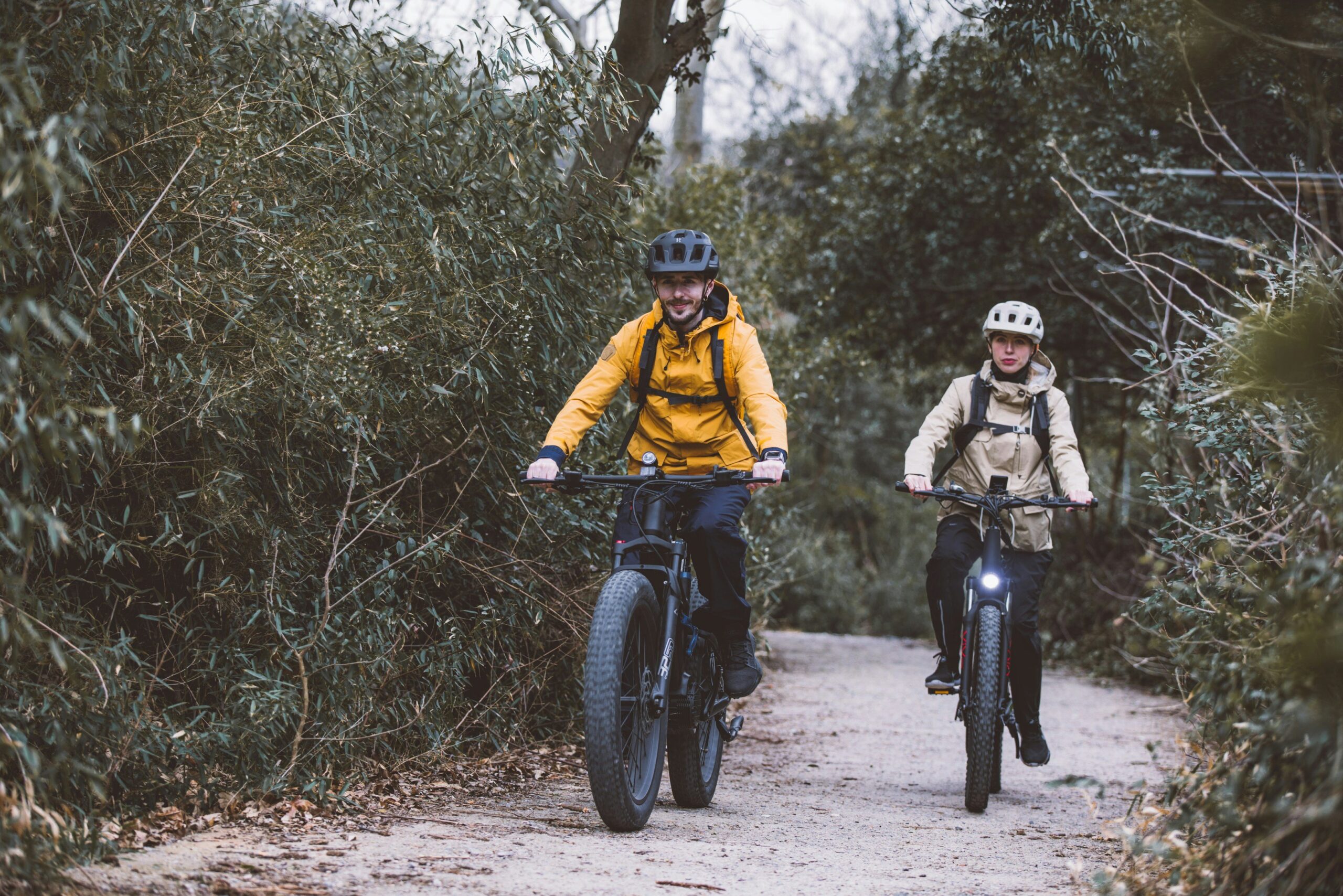 Panoramic view of mountain trails with cyclists enjoying e-bikes against blue skies