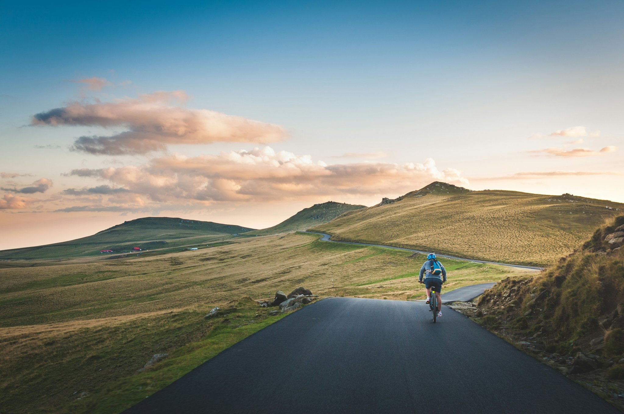 Scenic view of snowy peaks with an e-biker riding along a winding path.