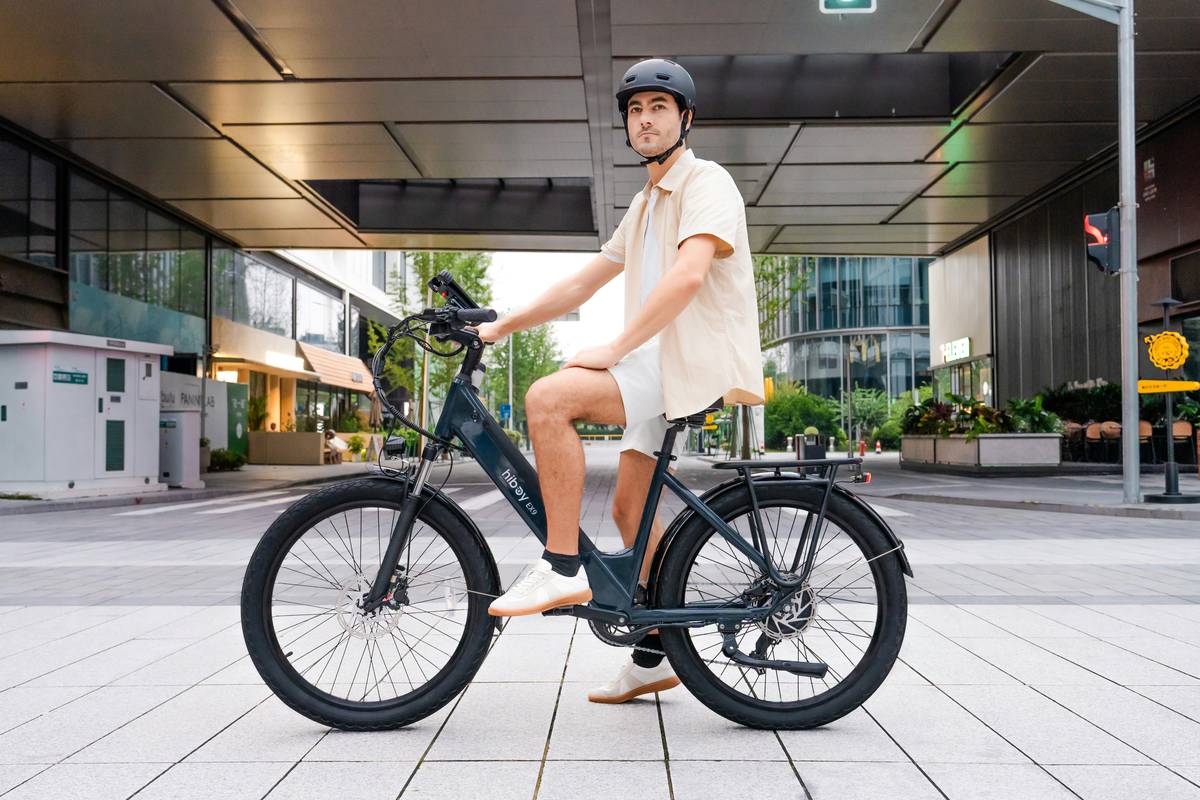 A cyclist gliding along a lush green urban pedal path surrounded by vibrant flowers