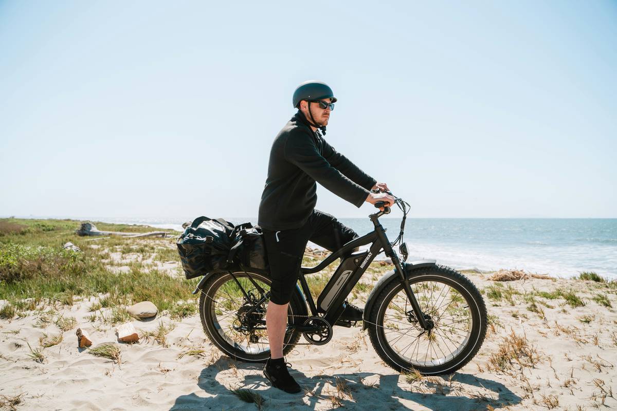 A cyclist riding an e-bike on a scenic forest path