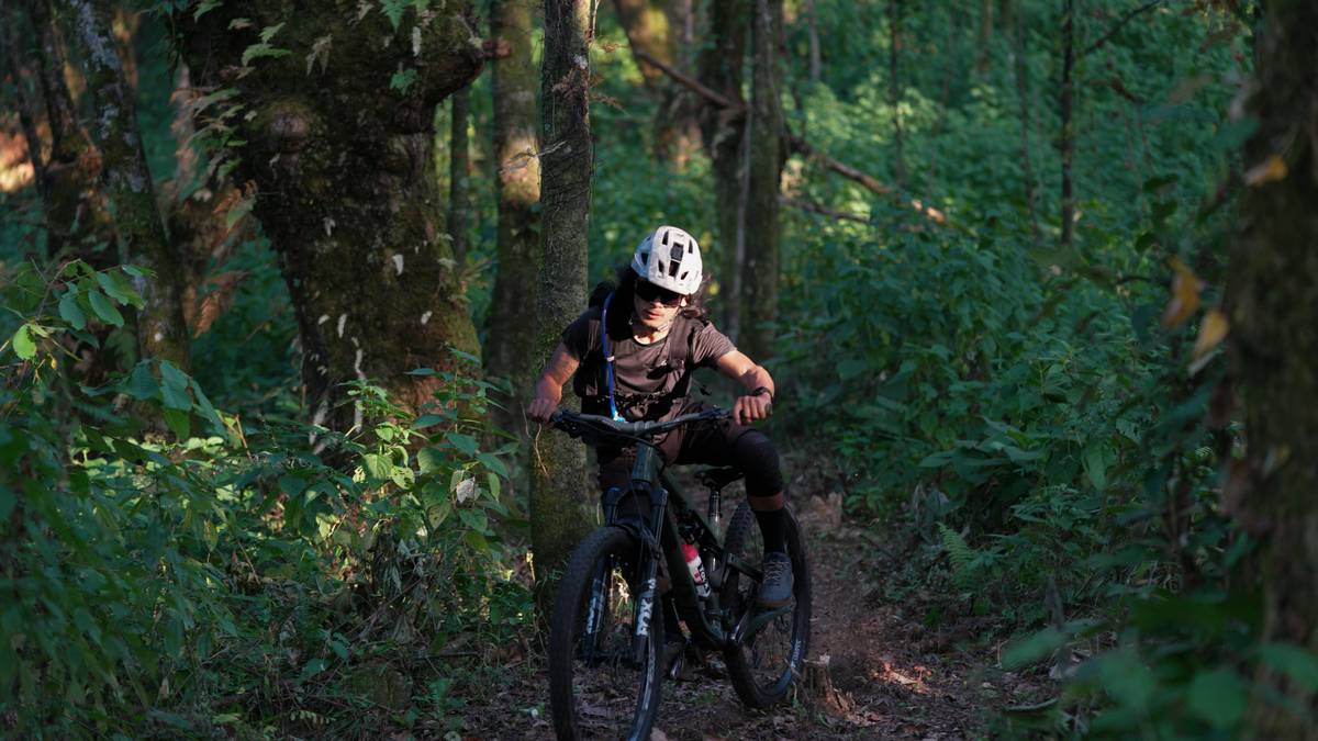 A group of tourists riding eBikes through a vibrant city street filled with colorful buildings and cafes.