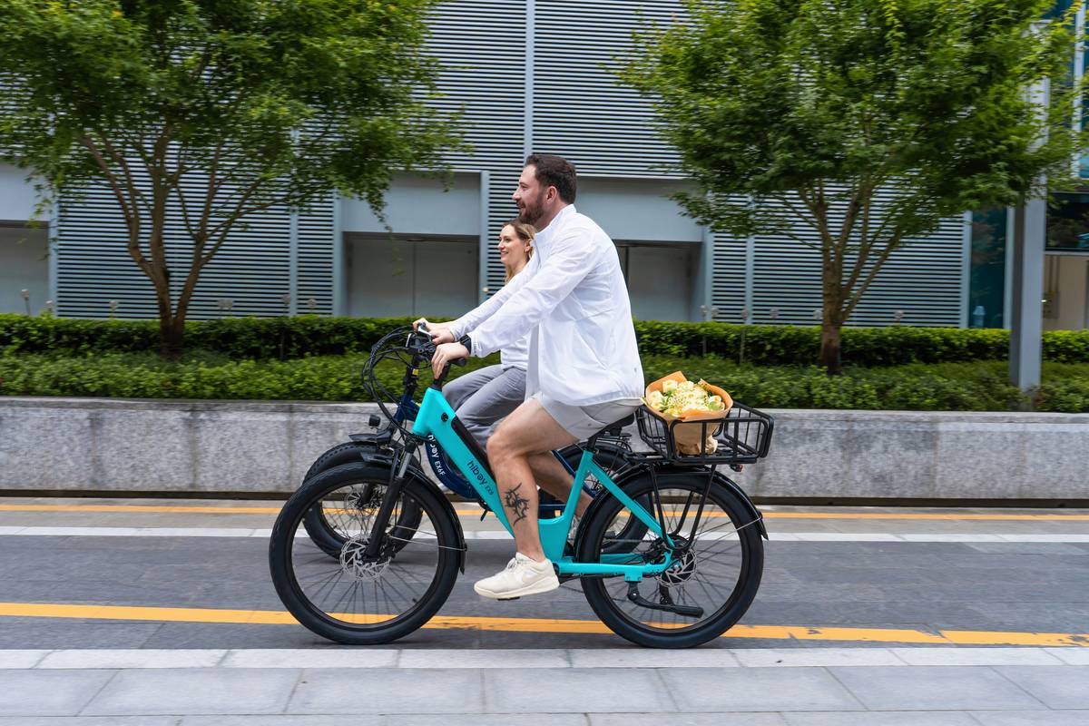 A group of tourists smiling as they ride green e-bikes along a scenic coastal path.