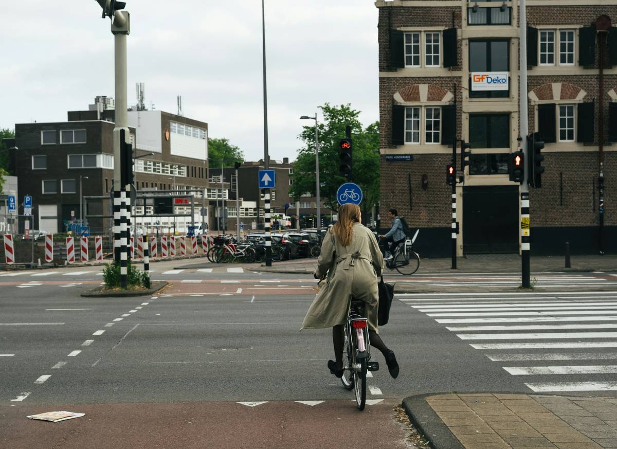 E-bike riders cruising down a scenic city street lined with cafes